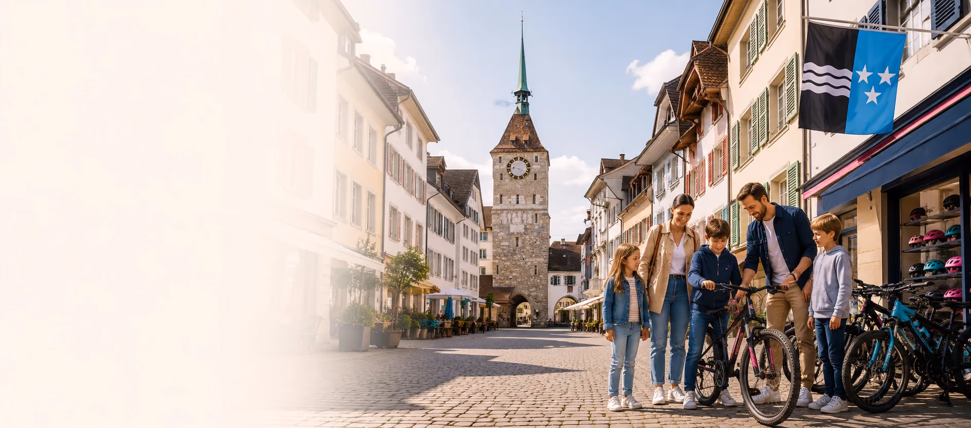 Familie vor einem Veloladen in einer Aargauer Altstadtgasse, im Hintergrund ein Uhrturm