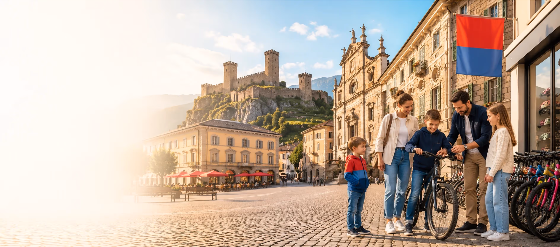 Familie vor einem Veloladen auf einer Piazza in Bellinzona, im Hintergrund die Burg