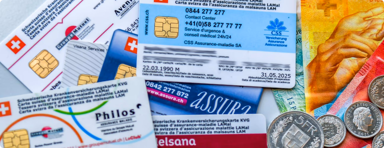 Cartões suíços de seguro de doença junto a notas e moedas de francos
